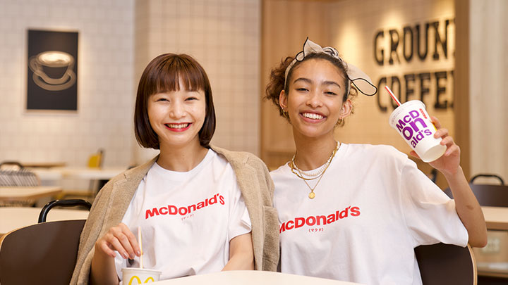Two girls in McDonald's t-shirts sitting in a McDonald's restaurant