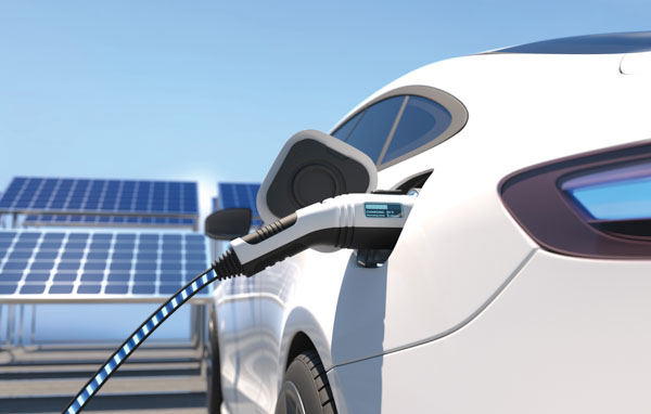 electrical-vehicle-being-charged-next-to-solar-panel