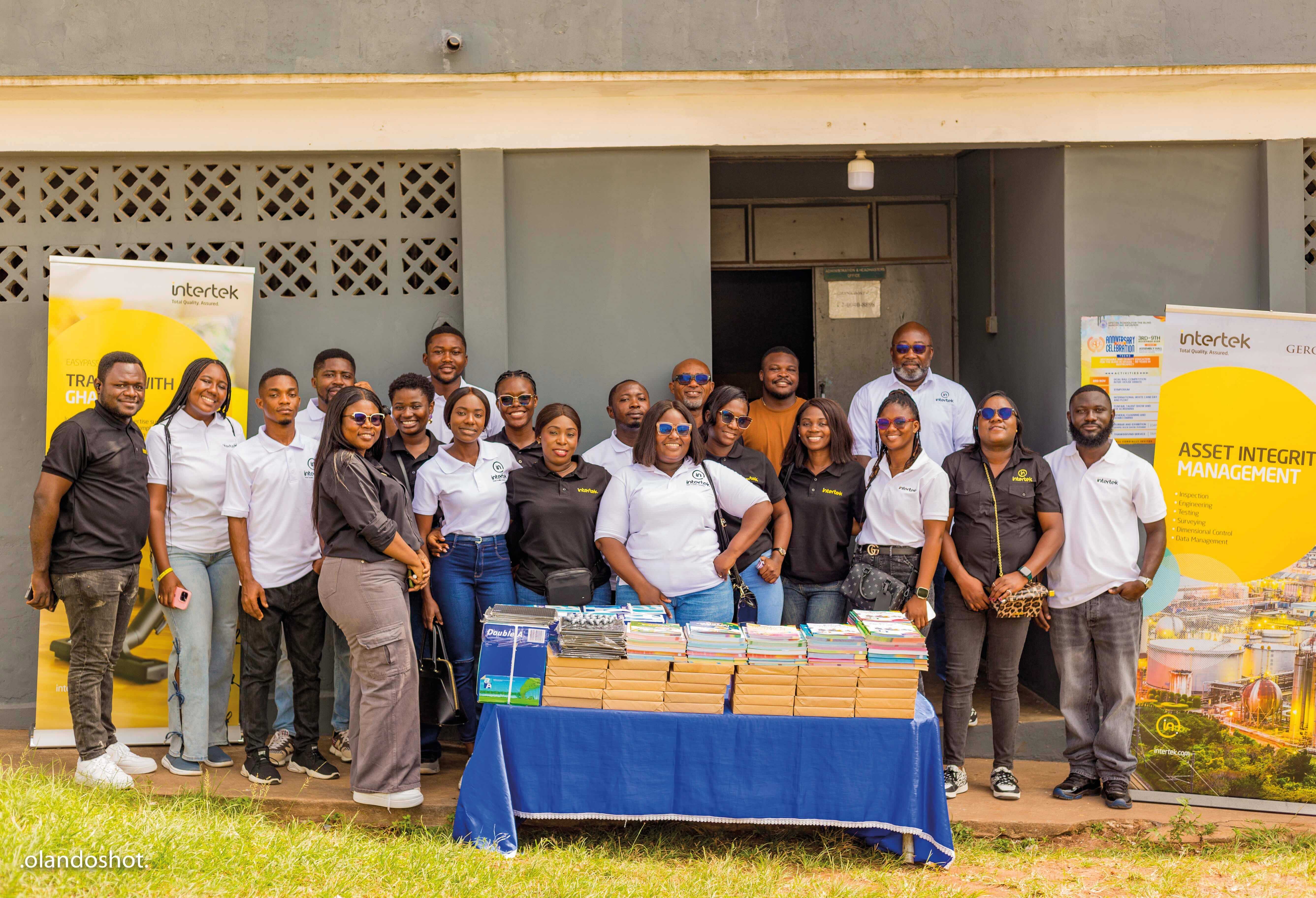 Intertek Ghana team poses with books collected for a school for blind children